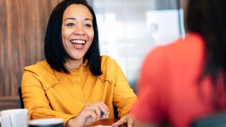 Customer-centric employee smiling while working with a client.