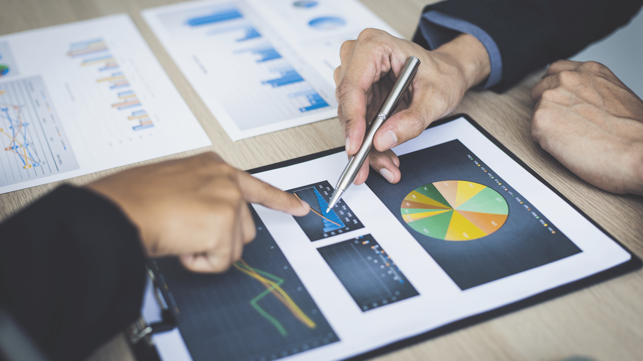Business professionals reviewing charts and graphs related to customer retention strategies.